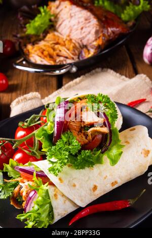 Leckere Wraps mit zog Schweinefleisch und Salat gefüllt Stockfoto