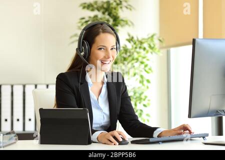 Happy tele Vermarkter arbeiten an der Kamera sitzt mit einem Desktop-Computer im Büro Stockfoto