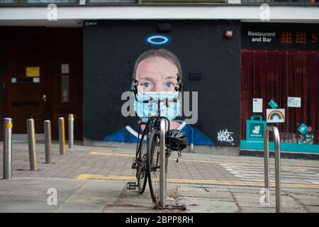 MANCHESTER, Großbritannien EIN Fahrrad, das vor einem Wandgemälde einer Krankenschwester mit einer PSA-Gesichtsmaske geparkt wurde, das der Künstler Akse im Northern Quarter von Manchester gemalt hat. Dienstag, 19. Mai 2020. (Quelle: Pat Scaasi) Quelle: MI News & Sport /Alamy Live News Stockfoto