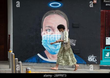 MANCHESTER, Großbritannien EINE Person geht vor einem Wandbild einer Krankenschwester mit einer PPE-Gesichtsmaske, das der Künstler Akse im Northern Quarter von Manchester gemalt hat. Dienstag, 19. Mai 2020. (Quelle: Pat Scaasi) Quelle: MI News & Sport /Alamy Live News Stockfoto