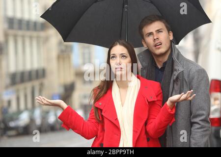 Porträt von wenigen angewidert verärgert an einem regnerischen Tag unter dem Regen und ein Regenschirm im winter Stockfoto