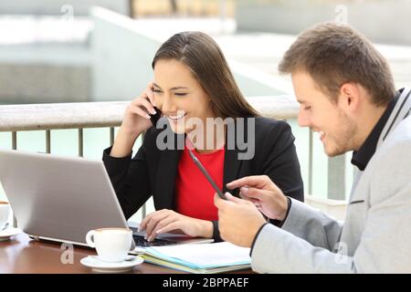 Zwei Führungskräfte Anrufen auf Telefon und zusammen arbeiten, sitzen in einer Bar Stockfoto