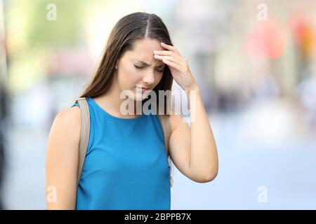 Single Frau mit Kopfschmerzen gehen auf die Straße Stockfoto