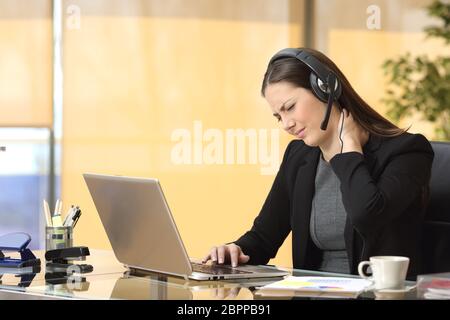 Gestresste Geschäftsfrau Hals Schmerzen und Leiden arbeitet an Linie in einem Desktop im Büro sitzen Stockfoto