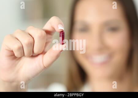 In der Nähe von eine glückliche Frau Hand zeigen eine Medizin Kapsel Stockfoto