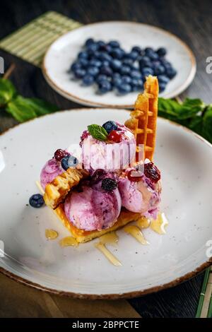 Wald Fruchteis dekoriert mit leckeren Waffeln und Honig nachfüllen Stockfoto