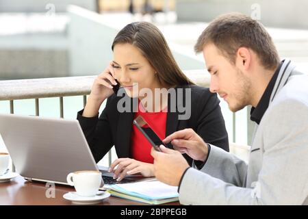 Zwei Führungskräfte coworking auf Linie in einem Café sitzen Stockfoto