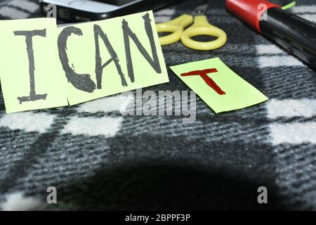 Motivierende ' ich kann ', T Buchstabe steht weit weg, also sagt es nicht, daß Sie kippen aber es Sie können sagt.Schere, Mobile u. Markierung im Hintergrund. Stockfoto