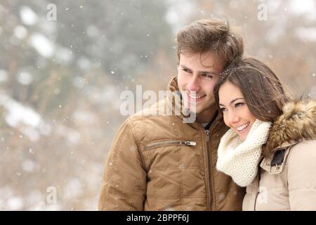 Glückliches Paar Verliebtheit weg schauen in einer verschneiten Winter Stockfoto