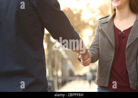 In der Nähe von eine glückliche Frau und Mann die Hände handshking auf der Straße Stockfoto