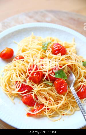 Cherry Tomaten in Olivenöl und Knoblauch über Pasta gekocht Stockfoto