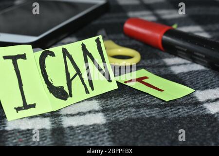 Motivierende ' ich kann ', T Buchstabe steht weit weg, also sagt es nicht, daß Sie kippen aber es Sie können sagt.Schere, Mobile u. Markierung im Hintergrund. Stockfoto