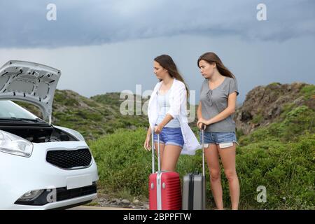 Zwei frustriert Touristen an der Motorhaube öffnen einer Panne Auto suchen Stockfoto