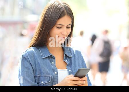 Teenager verwendet ein smart phone auf der Straße Stockfoto