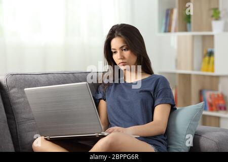 Apathisch jugendlich mit einem Laptop auf der Couch im Wohnzimmer zu Hause sitzen Stockfoto