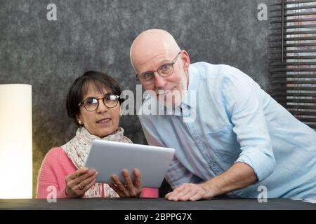 Gerne älteres Paar mit einem digitalen Tablet Stockfoto