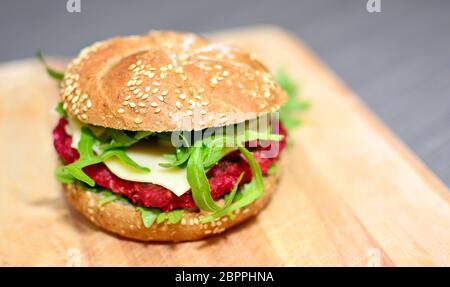 Nahaufnahme des beetrot Burger mit gegrillten Rucola auf Holzplatte. Stockfoto