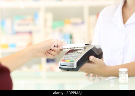 Nahaufnahme eines Kunden Hände mit Kreditkarte Leser in einer Apotheke bezahlen Stockfoto