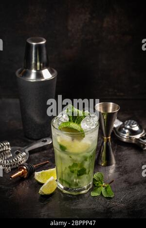 Mojito Cocktail mit Getränk und Tools auf schwarzem Hintergrund Stockfoto