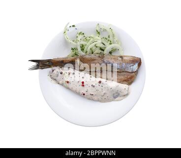 Close up Teil Salzwasser eingelegte Hering Fischfilets mit Zwiebeln und Soße auf weiße Platte auf weißem Hintergrund, erhöhte Ansicht von oben, direkt Stockfoto