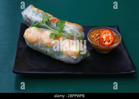 Nahaufnahme, Teil zwei frische Frühlingsrollen mit Garnelen und tauchen Chili Soße auf die Platte über der Tabelle, hohe Betrachtungswinkel Stockfoto