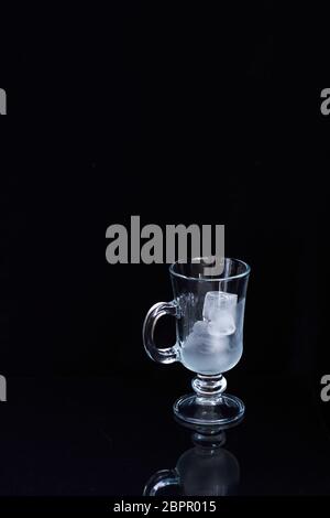 Leeres Latte Glas mit Eis auf schwarzem Hintergrund, Eis-Drink-Konzept Stockfoto