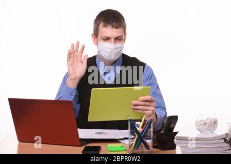 Ein Mann im Büro kommuniziert per Video und begrüßt den Gesprächspartner Stockfoto