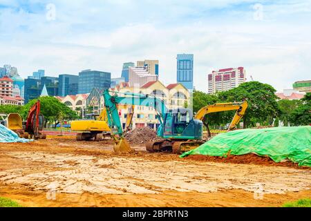 Baustelle Maschinen und graben Bagger arbeiten an Singapore Downtown street Stockfoto
