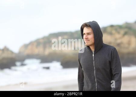 Porträt eines zuversichtlich Teenagers zu Fuß am Strand an einem regnerischen Tag Stockfoto