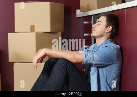 Seitenansicht Porträt einer traurigen Mann Umzug in der kintchen Etage sitzen Stockfoto