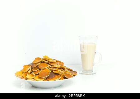 Trendy Pfannkuchen Müsli mit Milch auf weißem Hintergrund. Winzige gebackene Pfannkuchen. Frühstück. Stockfoto