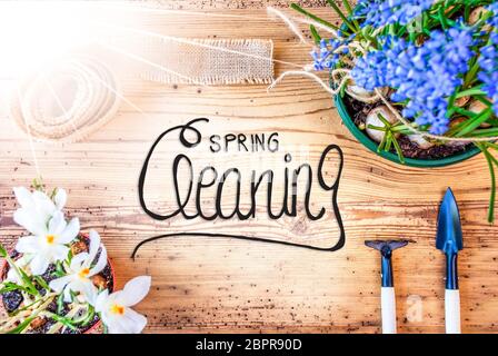 Englisch Kalligraphie Frühjahrsputz. Sonnige Frühling Blumen wie Traubenhyazinthen und Krokus. Gartengeräte wie Rechen und Schaufel Stockfoto