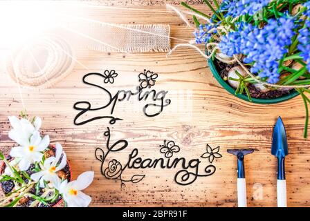 Englisch Kalligraphie Frühjahrsputz. Sonnige Frühling Blumen wie Traubenhyazinthen und Krokus. Gartengeräte wie Rechen und Schaufel Stockfoto