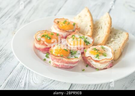 Speck und Ei Tassen mit gerösteten Brot auf die weiße Platte Stockfoto