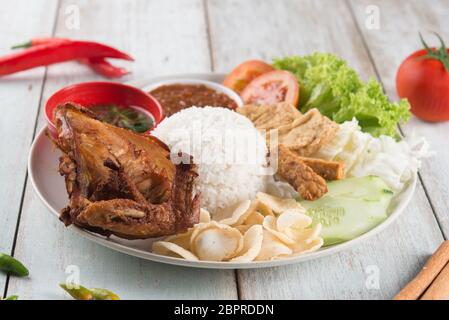 Nasi Lemak kukus mit gebratenen Hähnchen, beliebten traditionellen malaysischen lokalen Essen. Stockfoto