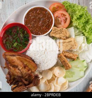 Nasi Lemak kukus mit gebratenen Hähnchen, beliebten traditionellen malaysischen lokalen Essen. Flach nach oben Ansicht von oben. Stockfoto