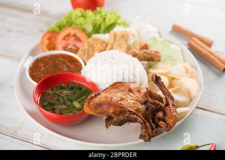 Nasi Lemak kukus mit gebratenen Hähnchen, beliebten traditionellen malaysischen lokalen Essen. Stockfoto