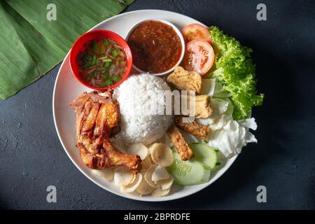 Nasi Lemak kukus mit gebratenen Drumstick, beliebten traditionellen malaysischen lokalen Essen. Flach nach oben Ansicht von oben. Stockfoto