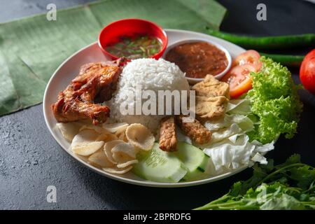 Nasi Lemak kukus mit gebratenen Drumstick, beliebten traditionellen malaysischen lokalen Essen. Stockfoto