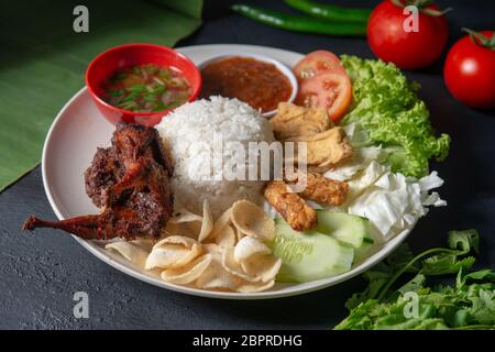 Nasi Lemak kukus mit Wachtel Fleisch, beliebten traditionellen malaysischen lokalen Essen. Stockfoto