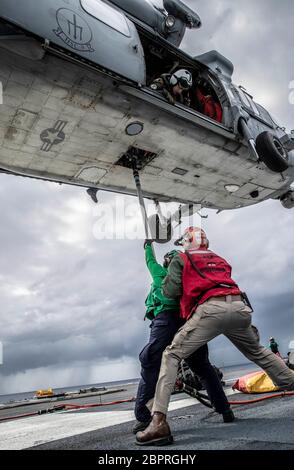 Logistik-Spezialist 3. Klasse Dienstag Silvers, aus Libanon, Indiana, zugewiesen USS Gerald R. Ford (CVN 78) Versorgungsabteilung, verriegelt eine Fracht Anhänger auf dem Boden eines MH-60S Sea Hawk Hubschrauber an den "Tridents" von Helicopter Sea Combat Squadron (HSC) 9 während einer vertikalen Auffüllung 15. Mai 2020. Ford ist im Atlantik unterwegs und führt die Qualifikationen von Spediteur durch. (USA Navy Foto von Mass Communication Specialist Seaman Riley McDowell) Stockfoto