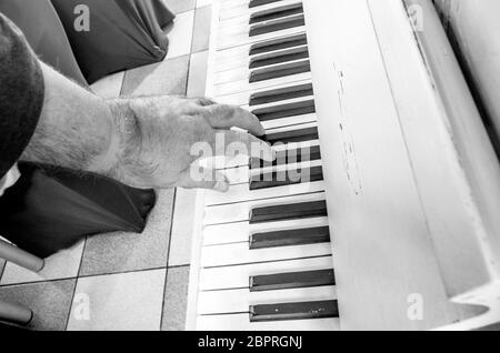 Süße Musik mit den Tasten mit den Fingern der Hand des alten Musiker gespielt Stockfoto