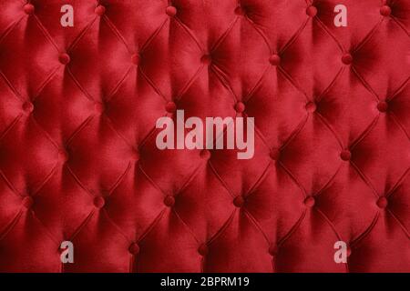 Maroon red velvet capitone Background, retro Chesterfield Stil kariert Soft getuftete Stoffmöbel Rautenmuster Dekoration mit Tasten Stockfoto