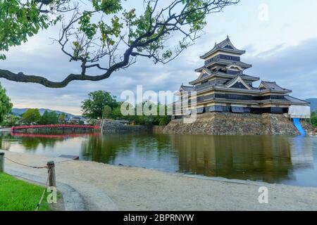 Sonnenuntergang Blick auf das Matsumoto Castle (oder Crow Castle) und die Brücke, in Matsumoto, Japan Stockfoto