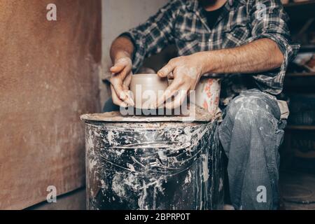 Töpfermeister arbeitet auf Töpferscheibe in der Werkstatt Stockfoto