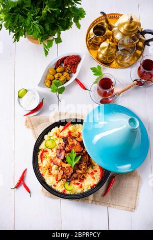 Tajin mit Couscous, Gemüse und Fleisch auf weißem Hintergrund Stockfoto