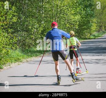 Vater und Tochter trainieren auf den Rollerskater. Stockfoto