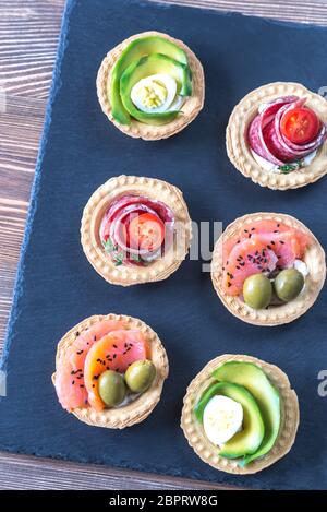 Törtchen mit verschiedenen Füllungen auf der Steintafel Stockfoto