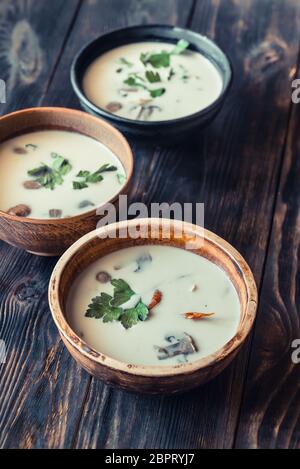 Schalen von Thai Tom Kha Suppe auf dem hölzernen Tisch Stockfoto