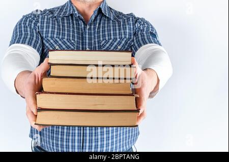 Mann in Blue Plaid Shirt halten eines der Bücher auf einem weißen Hintergrund Stapel Stockfoto